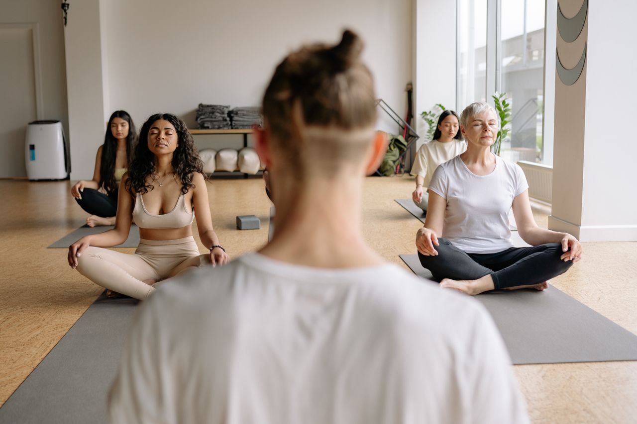 Peaceful meditation session with diverse group practicing yoga indoors.